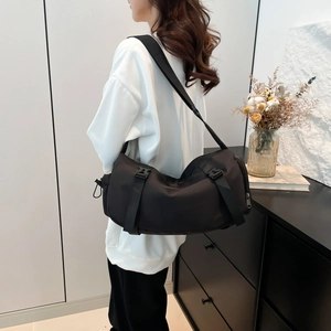 Large black nylon cylinder crossbody sports bag with adjustable straps and buckles