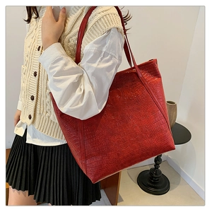 Detailed close-up of textured crocodile pattern on red large capacity tote bag for women