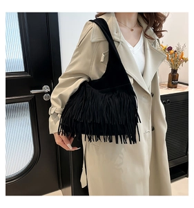 Close-up of black fringe tote bag with long tassels and soft matte suede texture