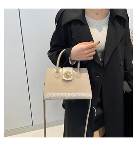 Detail of elegant beige crossbody bag featuring gold clasp and crocodile texture