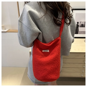 Detail of red teddy fleece bucket bag showing soft texture and brand woven label
