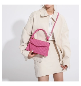 Detail of the rose red woven texture and elegant envelope flap on this handbag