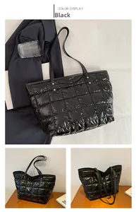 Detailed close-up of a black quilted tote bag with square embroidery and glossy finish
