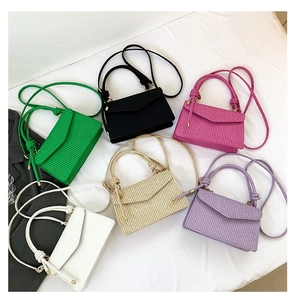 Detailed shot showing multiple colors of small square woven texture shoulder bags