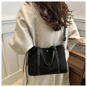 Model view of black suede bucket bag with silver studs and leather straps detail
