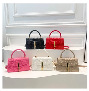 Multiple crocodile pattern crossbody bags in five colors on a tiered white display stand