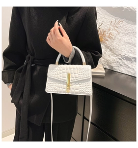 Detailed view of white crocodile pattern crossbody bag with a sleek gold metal buckle