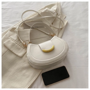 Dettaglio borsa a mezzaluna in pelle crema con elegante chiusura a semicerchio dorata