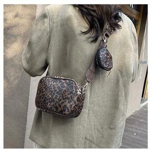 Detailed view of leopard print crossbody bag with detachable round coin purse and strap