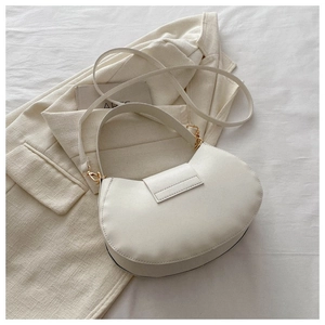 Dettaglio della borsa a mezzaluna in pelle PU crema con eleganti finiture dorate
