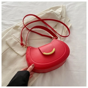 Dettaglio borsa a tracolla rossa a mezzaluna con fibbia dorata e trama in pelle