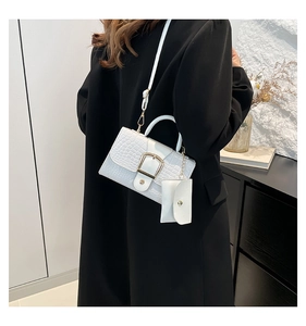Détail du sac à main blanc gaufré crocodile avec boucle dorée et mini porte-monnaie