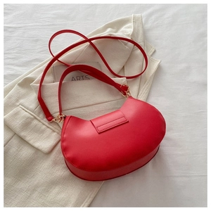 Borsa a tracolla a mezzaluna rossa in ecopelle con doppia tracolla su blazer bianco
