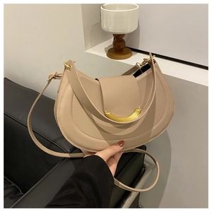 Dettaglio borsa a tracolla in pelle beige con fibbia metallica dorata a forma di mezzaluna