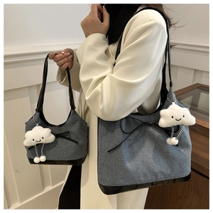 Dettaglio della borsa tote patchwork in tela grigia con fiocco e ciondolo a nuvola