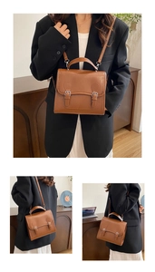 Detail view of a vintage British style brown briefcase bag with buckle straps and top handle
