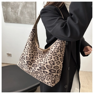 Nahaufnahme der Schultertasche mit Leopardenmuster und braunem Gurt an einem Model