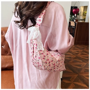 Detail of pink floral shoulder bag with white lace bow and ruffled crossbody strap