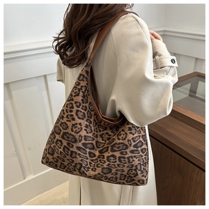 Detail der trendigen Schultertasche mit Leopardenmuster und beigem Trenchcoat