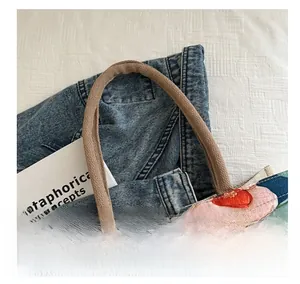 Detalle del bolso tote de lona con estampado floral retro y asas de cuerda resistentes