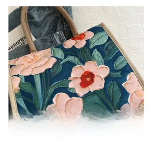 Detalle de bolso tote grande de lino con bordado floral y asas de fibra de yute
