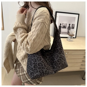 Detailansicht einer Leopard-Tasche kombiniert mit beigem Strickpullover und Karo-Rock