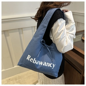 Detail van de blauwe canvas tas met Rebawancy-tekst en trekkoord met strik aan de zijkant