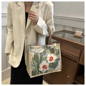 Detail of canvas tote bag with 3D floral pattern and braided rope handle for women