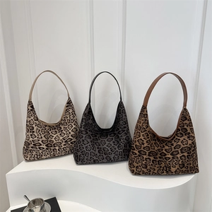 Three stylish leopard print hobo tote bags displayed on a minimalist white platform