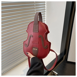 Detalle del bolso rojo con forma de violín con remaches dorados y costuras finas
