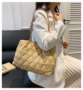 Dettaglio borsa shopper beige trapuntata con motivo a rombi e tracolle in ecopelle