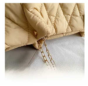 Dettaglio borsa shopper trapuntata beige con cuciture a rombi e catena dorata
