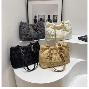 Detail view of the stylish quilted tote bag with chain strap and large capacity. Perfect style.