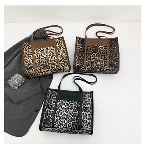 Three leopard print tote bags in gold, dark brown, and grey with contrast trim and handles