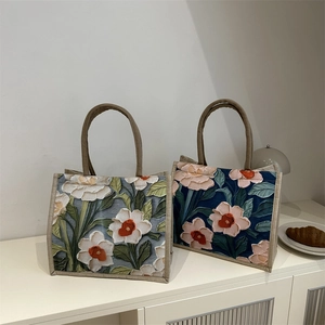 Large tote bag with 3D embossed floral patterns and woven handles for commute