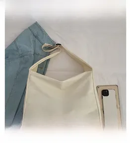 Detailed view of cream canvas tote bag featuring black MOOD letter print and wide strap