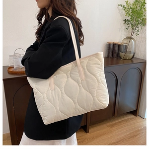 Détail du sac cabas matelassé blanc cassé avec surpiqûres ondulées sur tissu léger