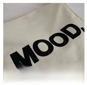 Detail shot of heavy-duty canvas tote fabric featuring bold MOOD. letter printing