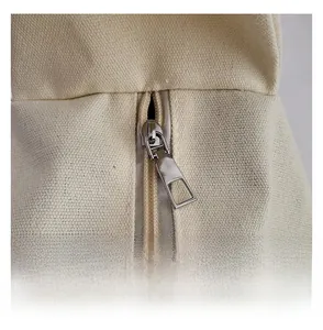 Detail shot of a smooth silver metal zipper on vintage cream-white canvas tote bag