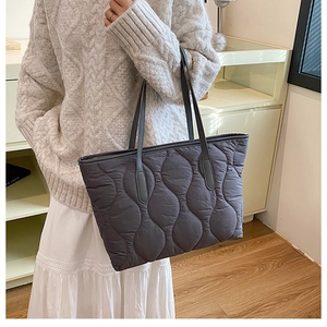 Détail du sac cabas matelassé gris foncé avec surpiqûres et fines anses en cuir