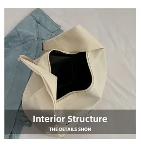 Internal structure of off-white canvas tote bag showing black lining and interior pockets