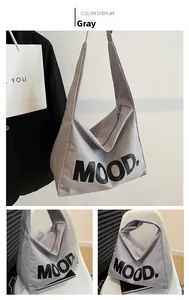 Detailed view of the gray canvas tote bag featuring black MOOD letter print and metal zipper
