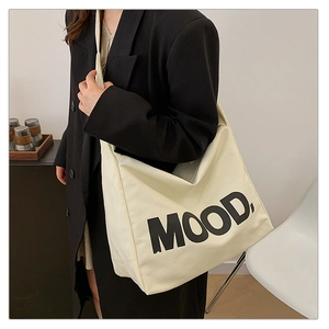 Dettaglio di una borsa tote in tela color crema con stampa MOOD per l'uso quotidiano