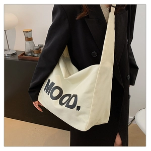 Detail of cream canvas tote bag with MOOD lettering and comfortable wide shoulder strap