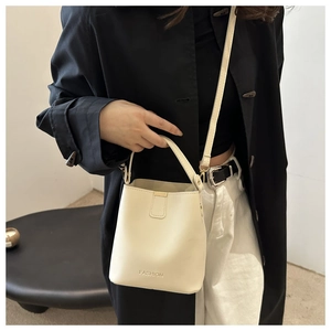 Modella che indossa una borsa a secchiello in pelle PU crema con logo e tracolla regolabile