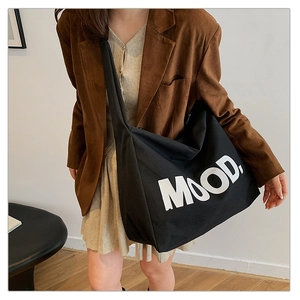 Detailed view of a large black canvas tote bag featuring a white bold MOOD letter print