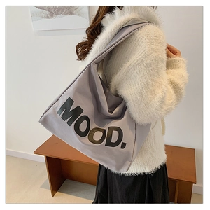 Detail of grey canvas tote bag with MOOD letter print and wide shoulder strap