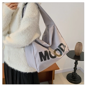 Detail of light grey canvas tote bag with MOOD lettering and silver zipper closure