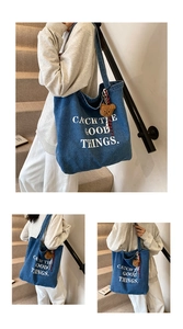 Close-up of blue denim tote bag with white text print and cute brown bear plush charm