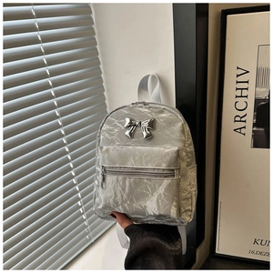 Silver metallic mini backpack with bow detail and crinkled texture for daily fashion style